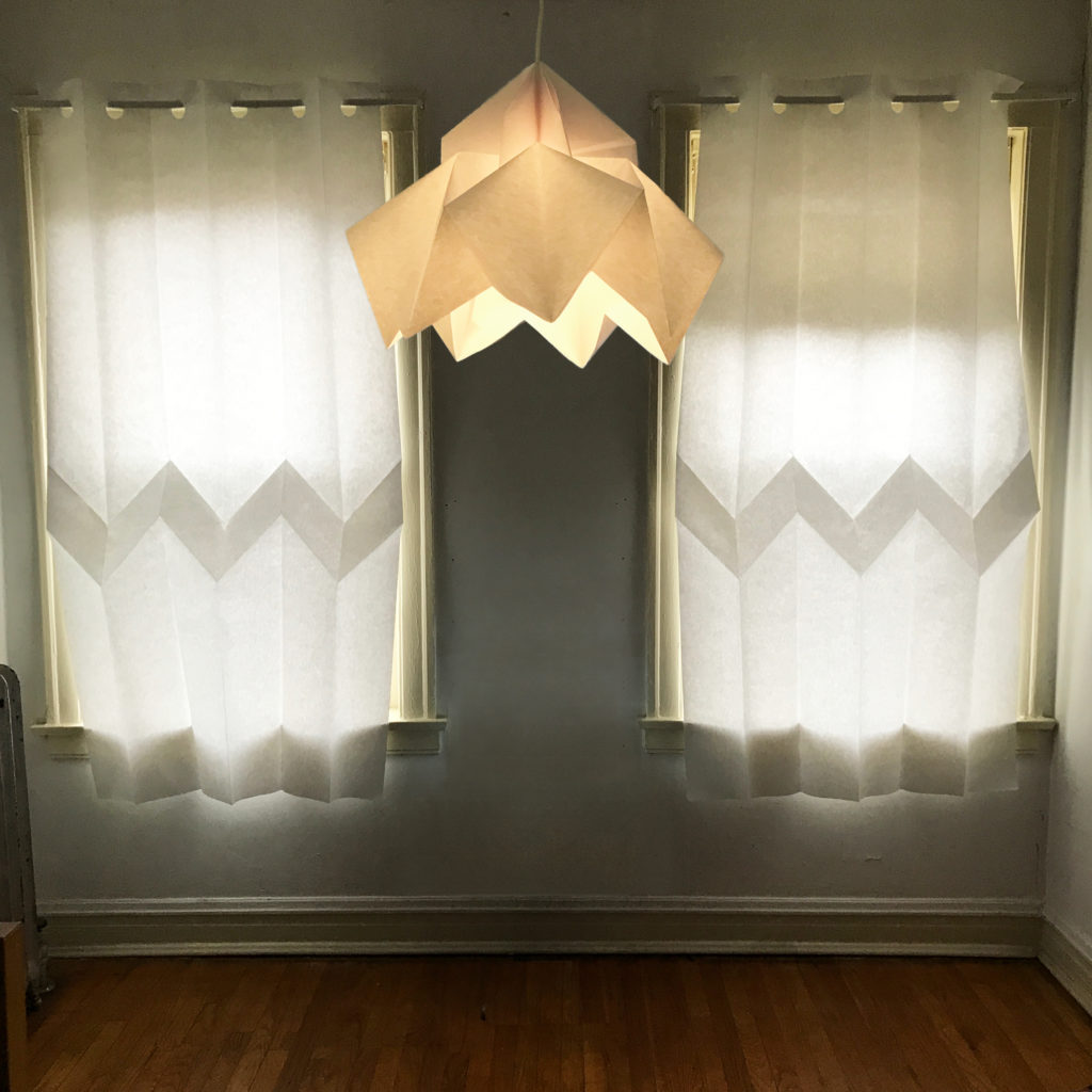 picture of paper curtains and chandelier, made using translucent white paper and folded with origami v-folds