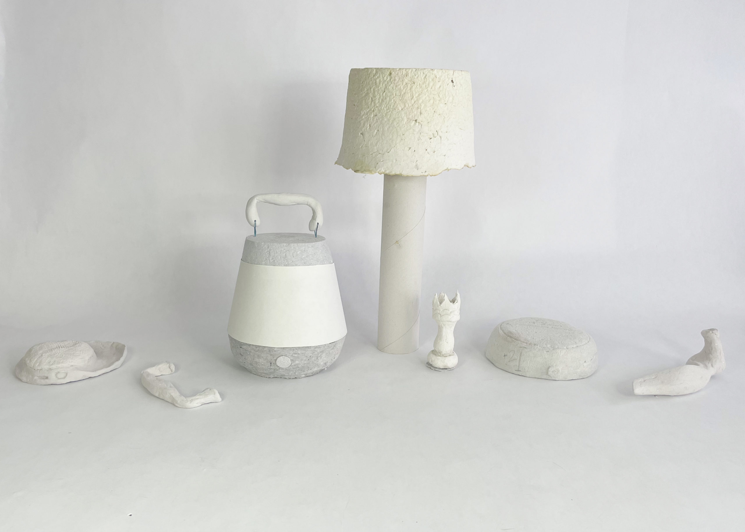 white models on a white background, from left to right: speaker, drawer pull, speaker, lamp, chess piece, speaker, door handle