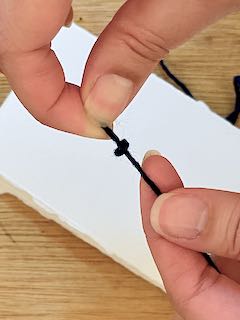 tying a knot in dark blue string