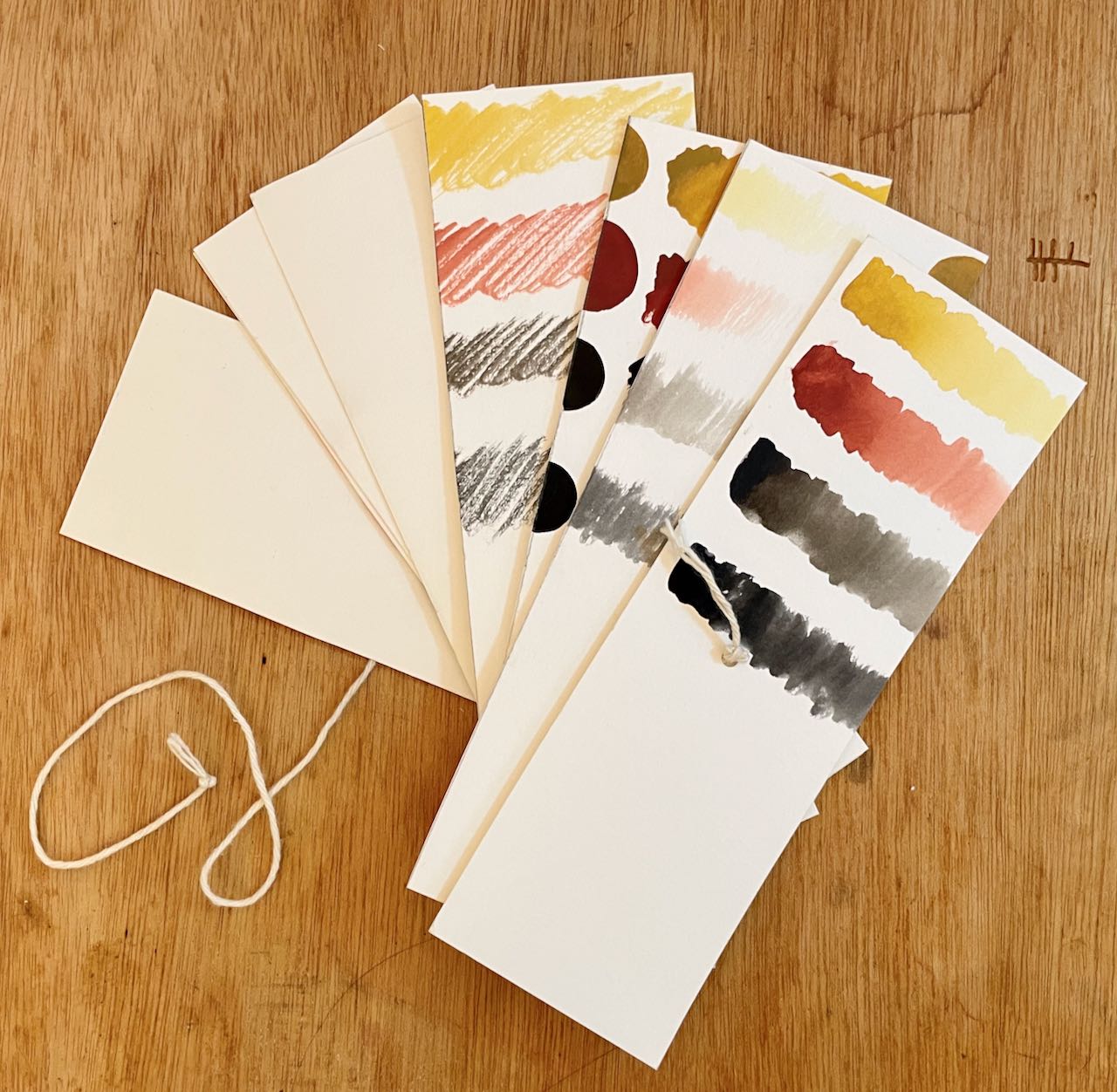 pothi book fanned out, page made from watercolor paper with earth tone color swatches on it